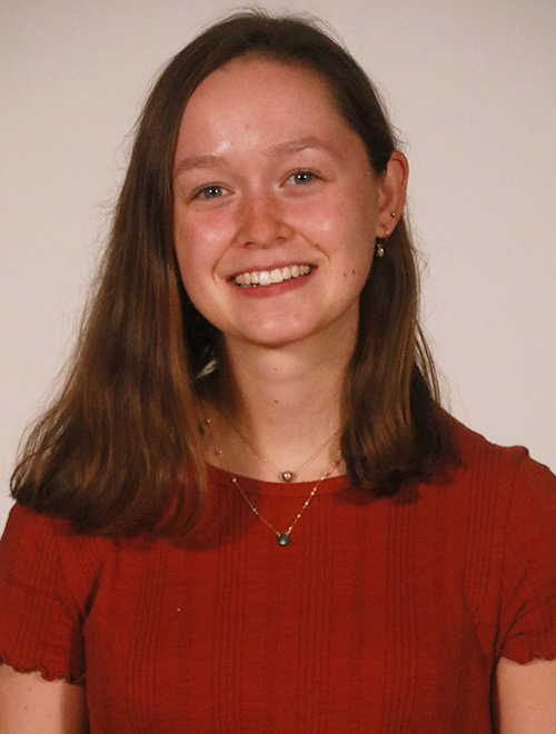 A headshot of Nicole Ducray '24 wearing a red short-sleeved blouse