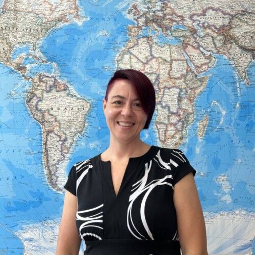 Dr. Amy Widestrom posing in front of global map.