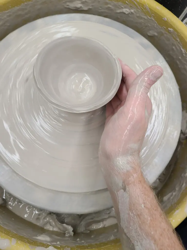 Clay being shaped into a bowl.