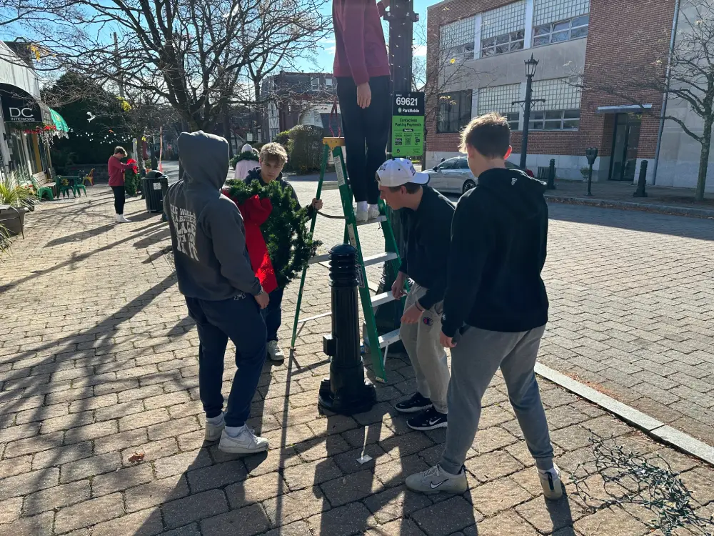 Students preparing to hang a wreath.