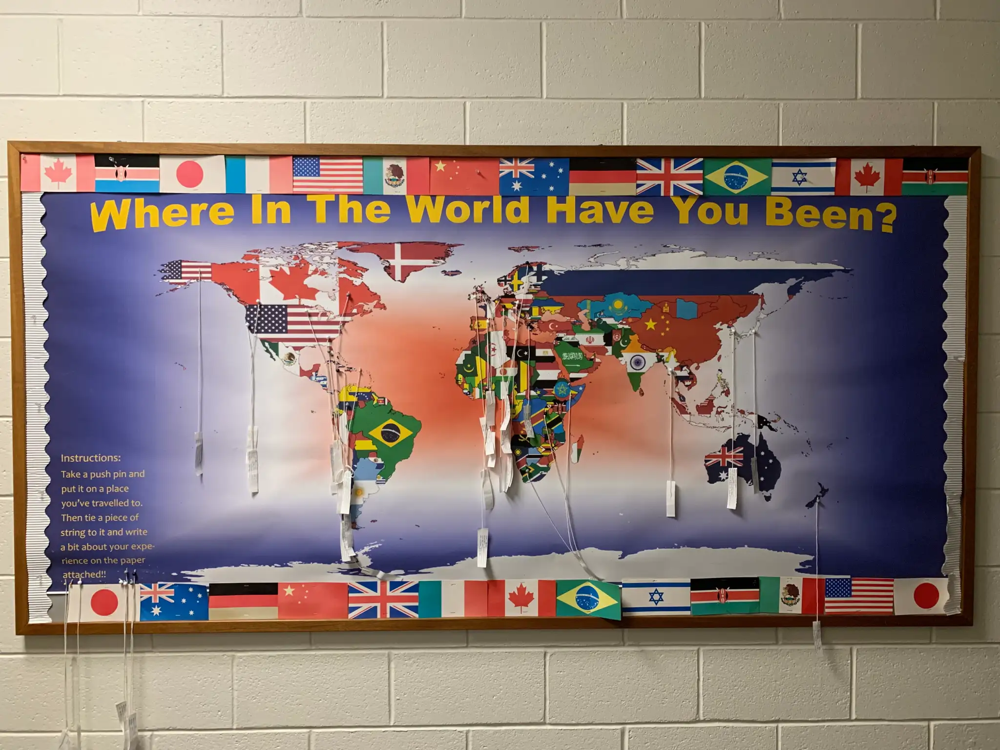 A bulletin board with a map of the world reading "Where in the World Have You Been?"