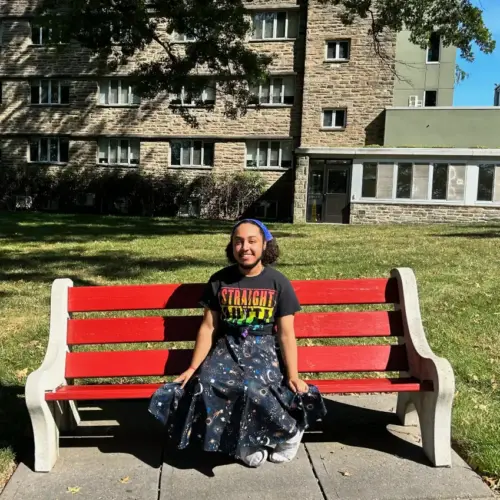 Ethan sitting on a bench on campus.