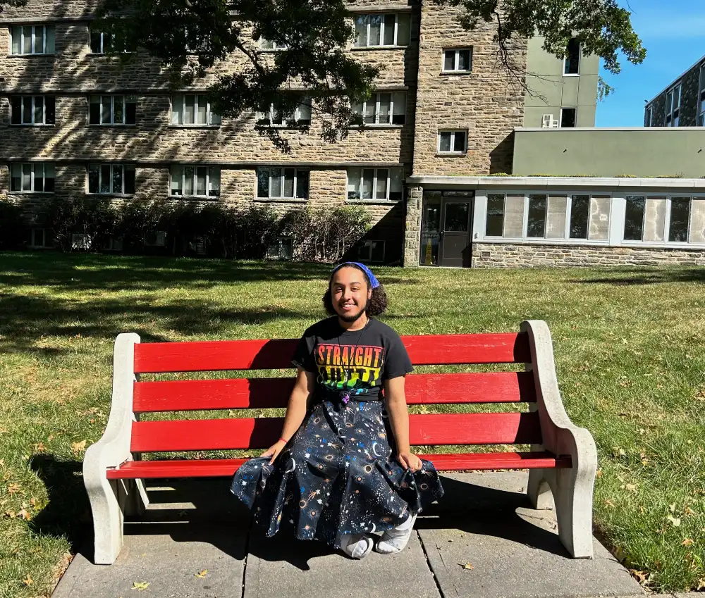 Ethan sitting on a bench on campus.