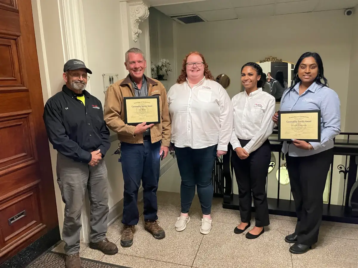 Staff from Arcadia's Facilities Management team stand together holding the Community Service Award they received from the township commissioners