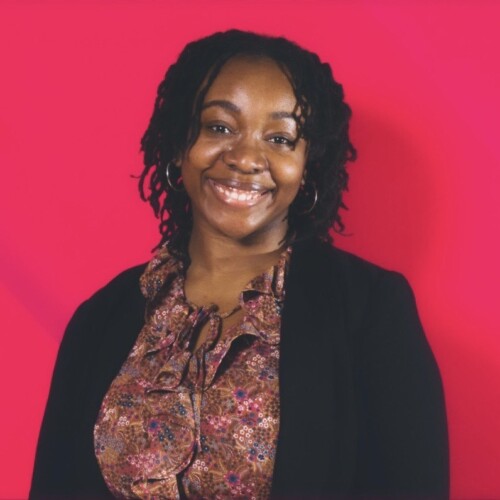 The headshot of a Black woman in a blouse with a black cardigan