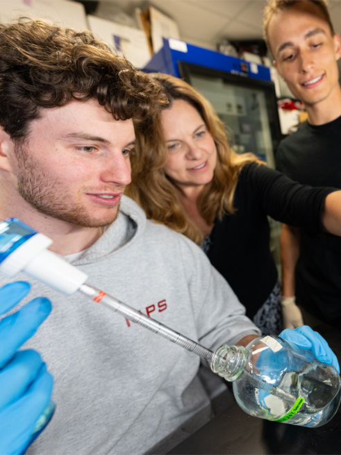 Dr. Sheryl Smith works in a lab with students on campus.