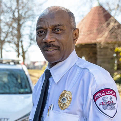 Sgt. Bruce Gant by a Public Safety vehicle on campus.