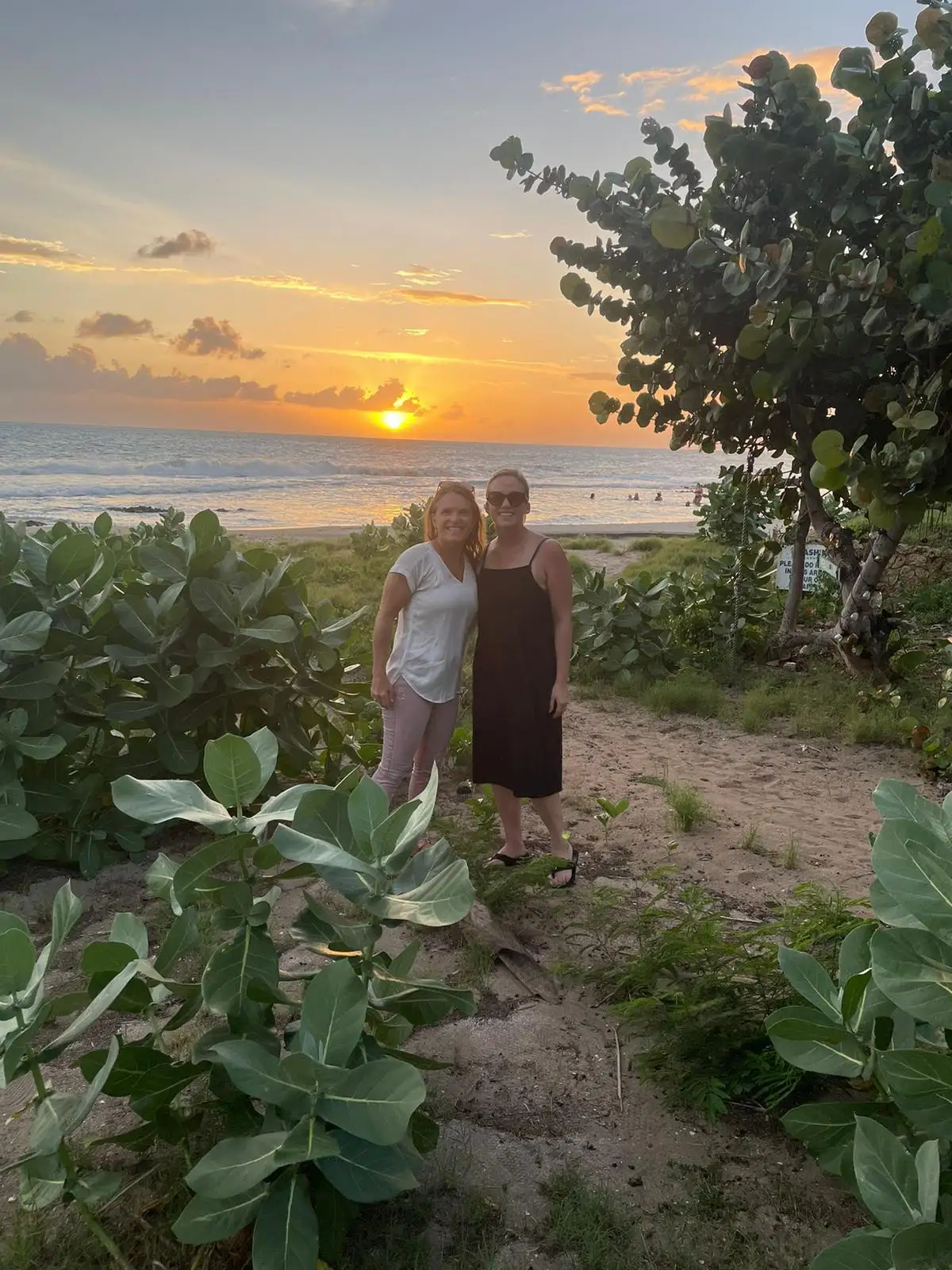 Two people standing on the beach.