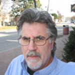 Dr. Matt Heitzman stand in front of a city street.