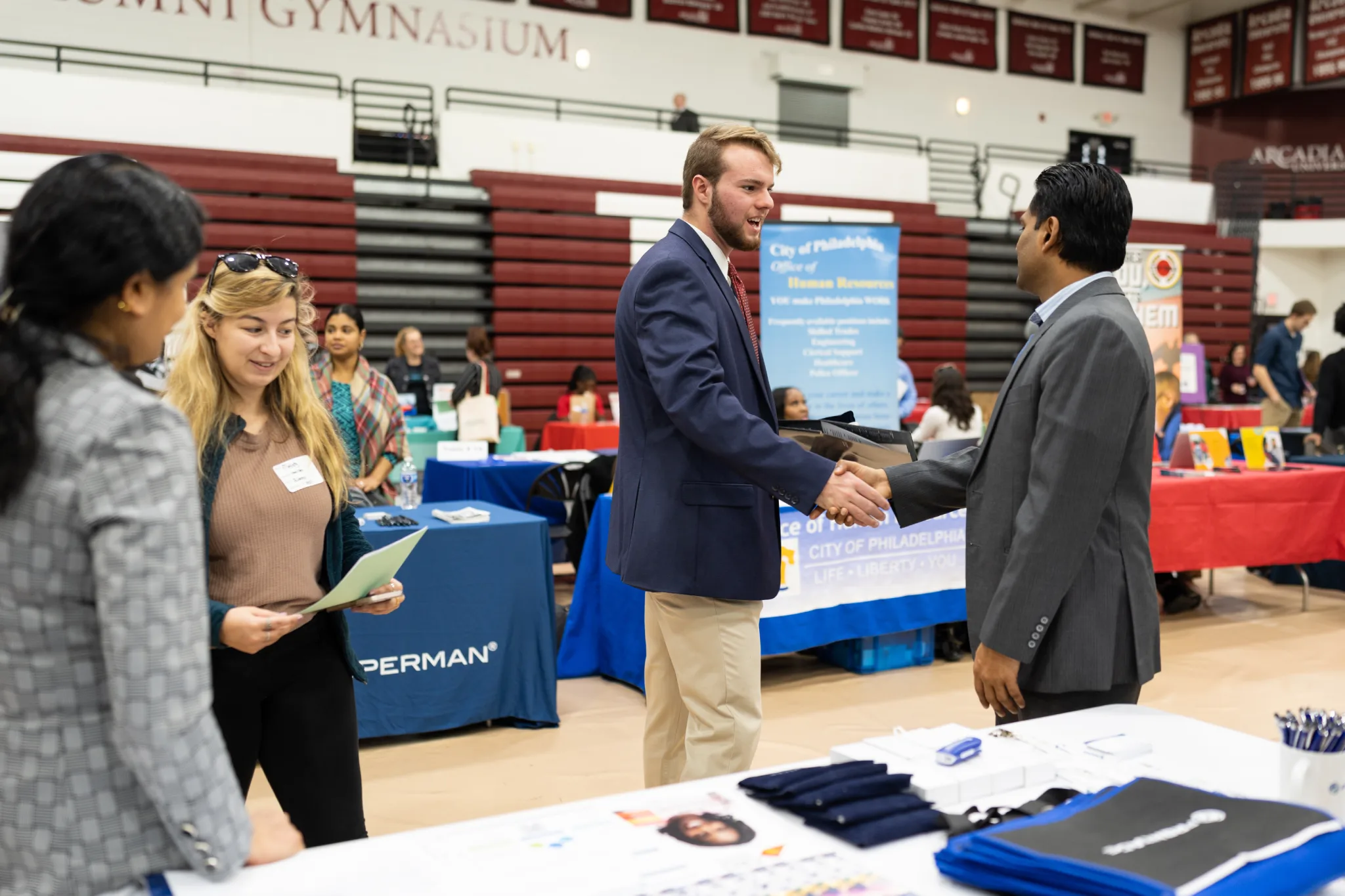 A student shaking the hand of an employer.