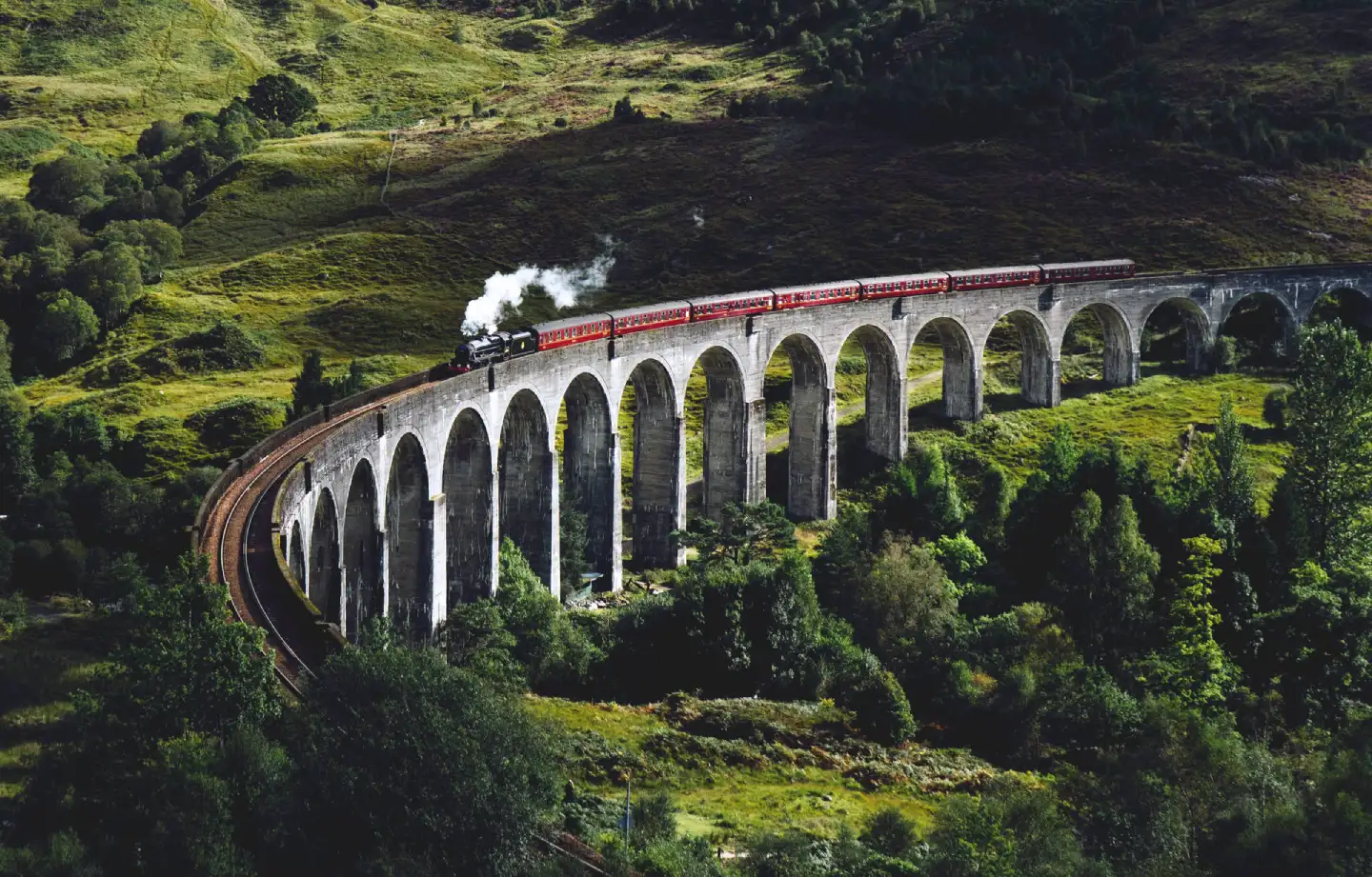 oyal Scotsman train across the Glenfinnan Viaduct in Scotland, made famous by the Harry Potter train: the iconic Hogwarts Express.