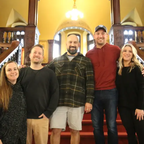Five graduates from the Class of 2007 stand together on The Grey Towers Castle staircase.