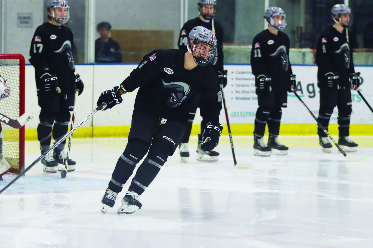 Max Finkeldey '26 on the ice with a few of his ice hockey teammates in the background