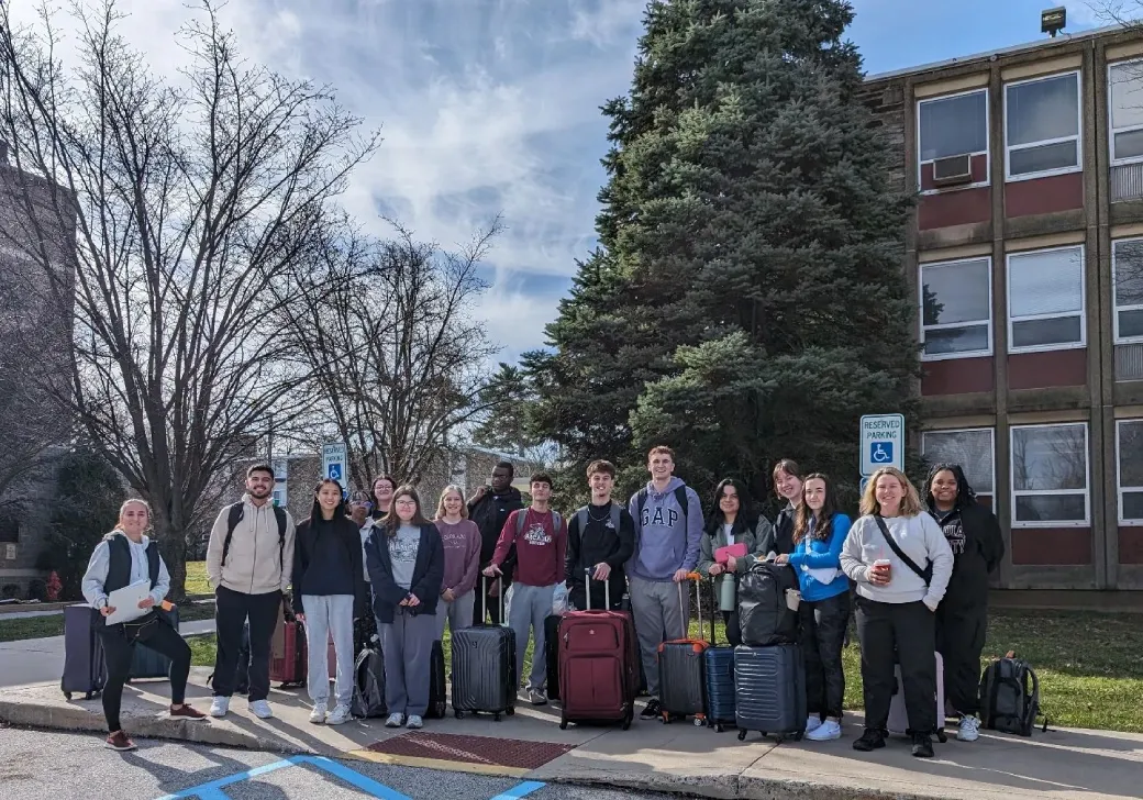 Students and the faculty/staff leaders of their Preview class outside Taylor Hall with their suitcases getting ready to leave for the airport for their Preview trip