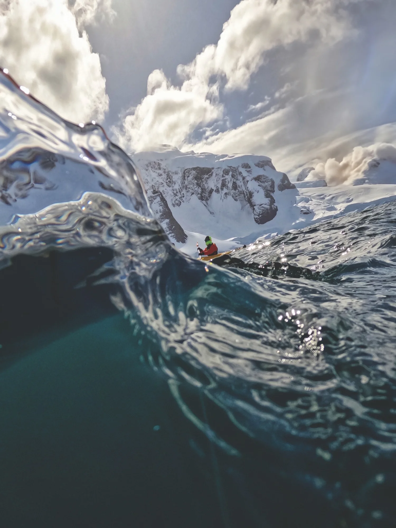 A kayaker can be seen behind an icy wave; photo taken by Aoife Samuelson '24, in Antarctica