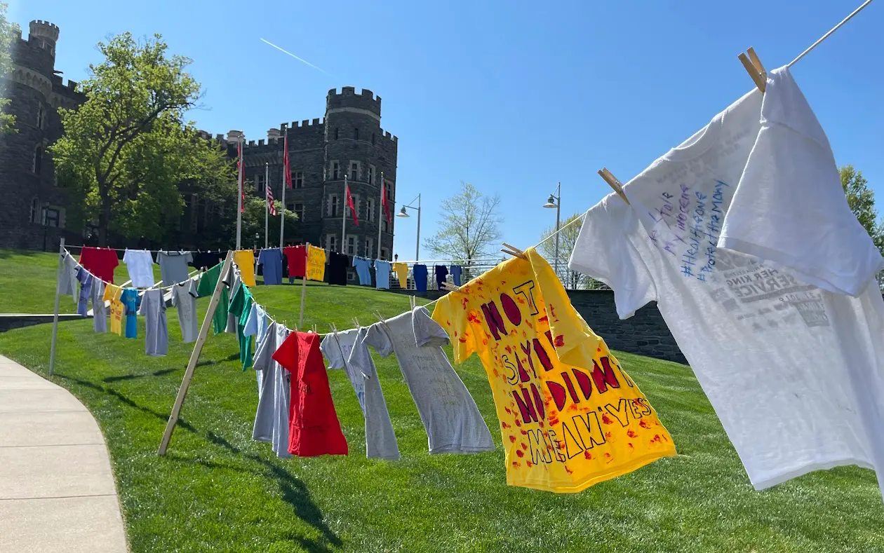 Brightly colored t-shirts hang on a clothes lines in front of Grey Tower Castle.