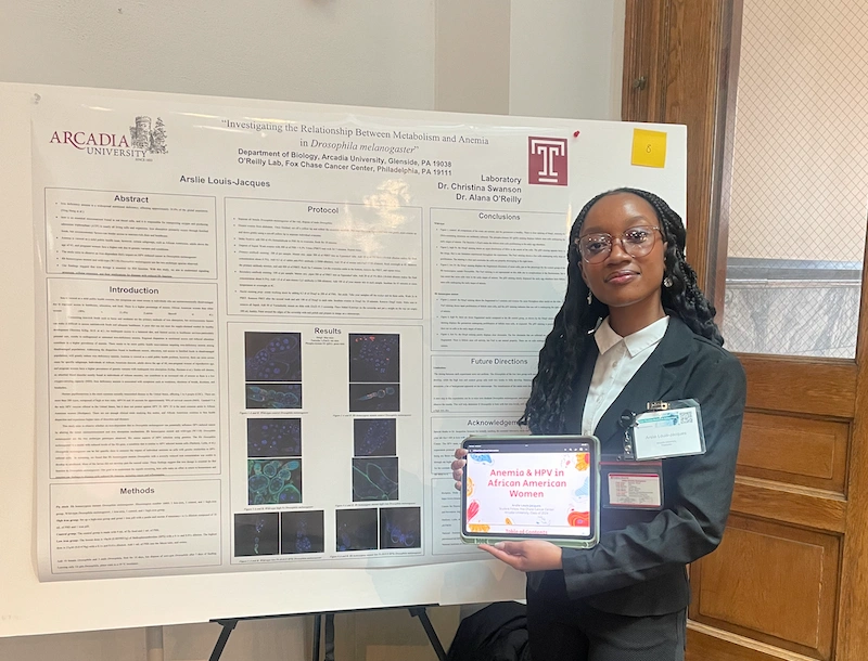 Arslie with her poster at the symposium.