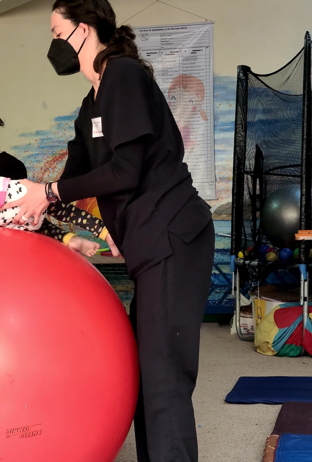 A PT student helping a patient with an exercise ball.
