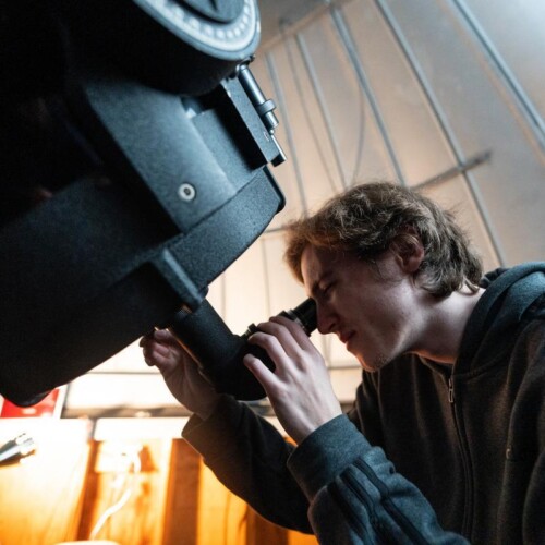Paul looking through a telescope.