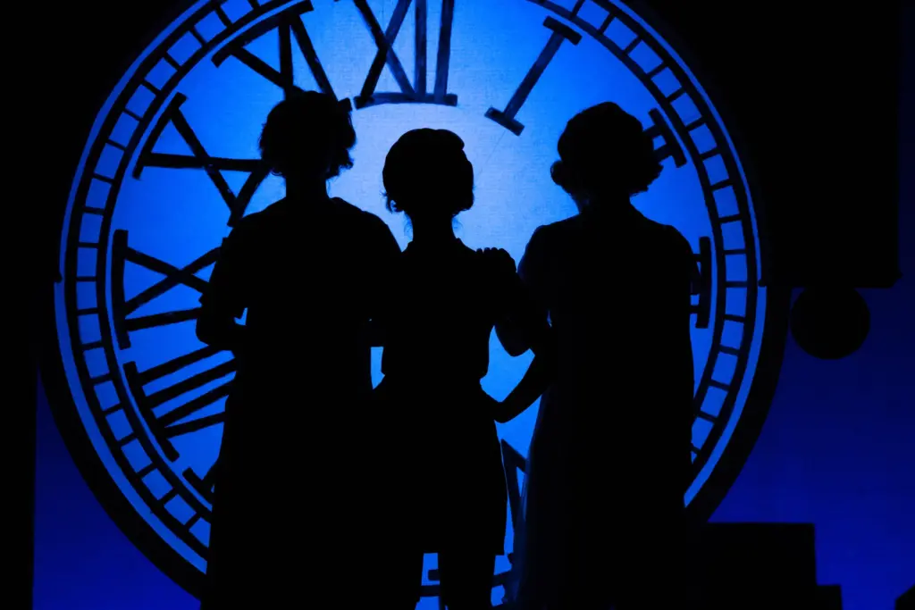 Three silhouettes of people with a blue background and clock tower