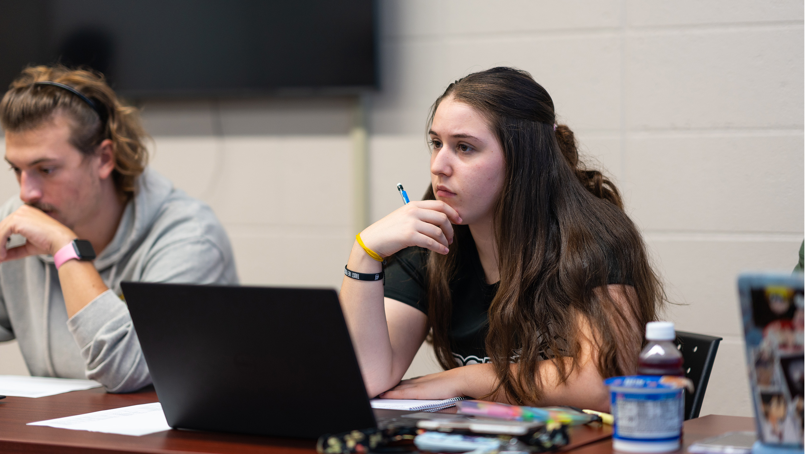 A special education major sits by another student during a lecture in a classroom on campus.