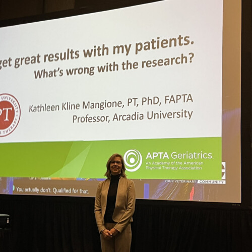 Dr. Mangione in front of her presentation slides.
