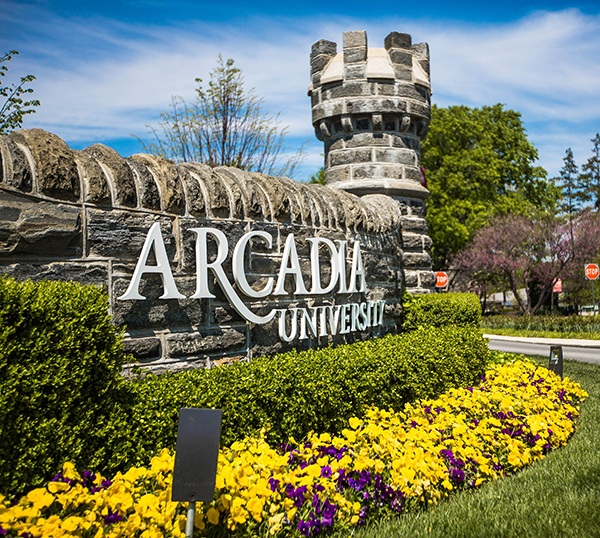 The stoney wall entrance for Arcadia University boasts a garden of blooms in the spring.