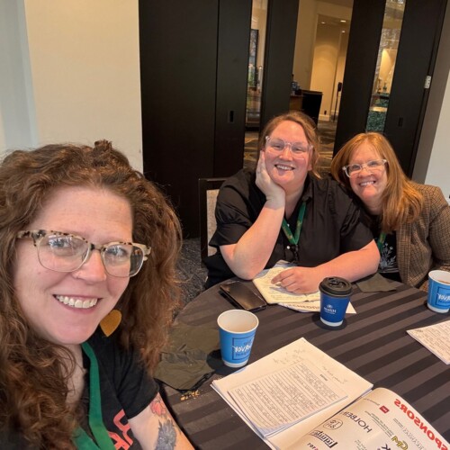 Profs. Carole Loeffler, Krista Profitt ’11, and Maryann Worrell ’05 sitting at a table after their conference session