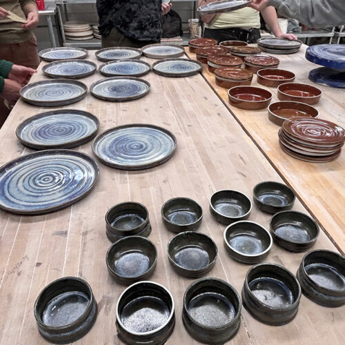 ceramic plates, bowls, and dessert dishes made by Arcadia students