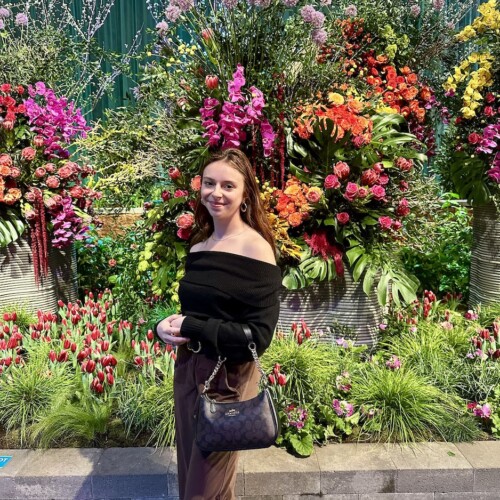 Maris Davis ’25 in front of lots of flowers.