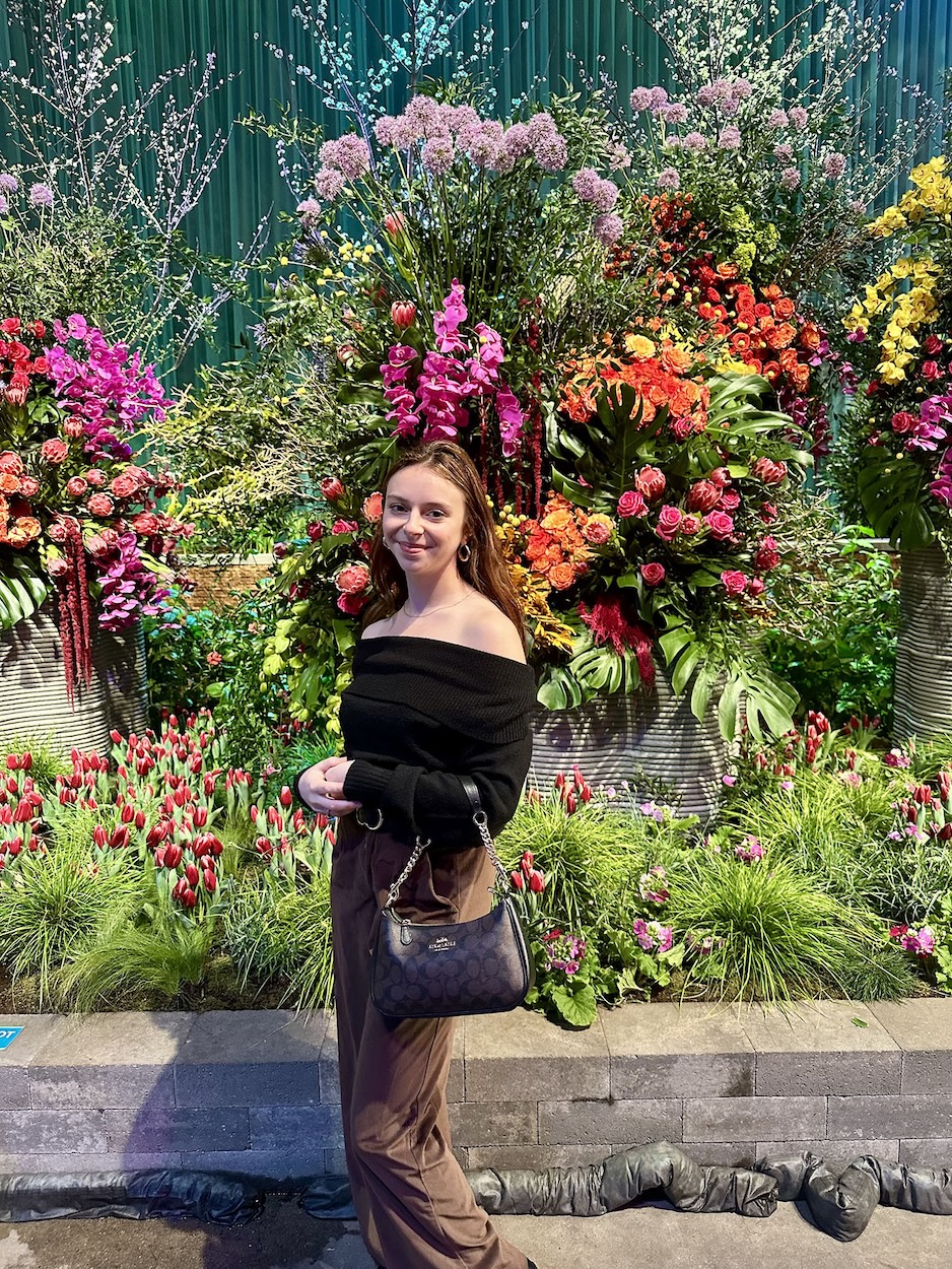 Maris Davis ’25 in front of lots of flowers.