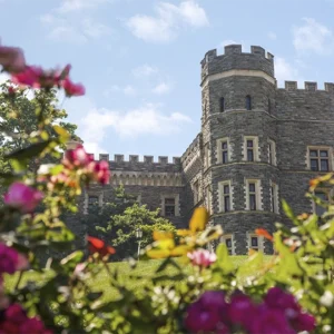 Grey Tower Castle is surrounded by spring blooms on a sunny day.