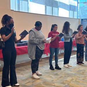 Members of the Arcadia community standing in the front of the room reading “Amari and the Night Brothers.”