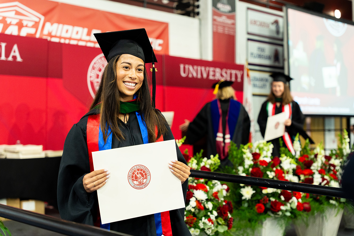 A student receiving their diploma at commencement.