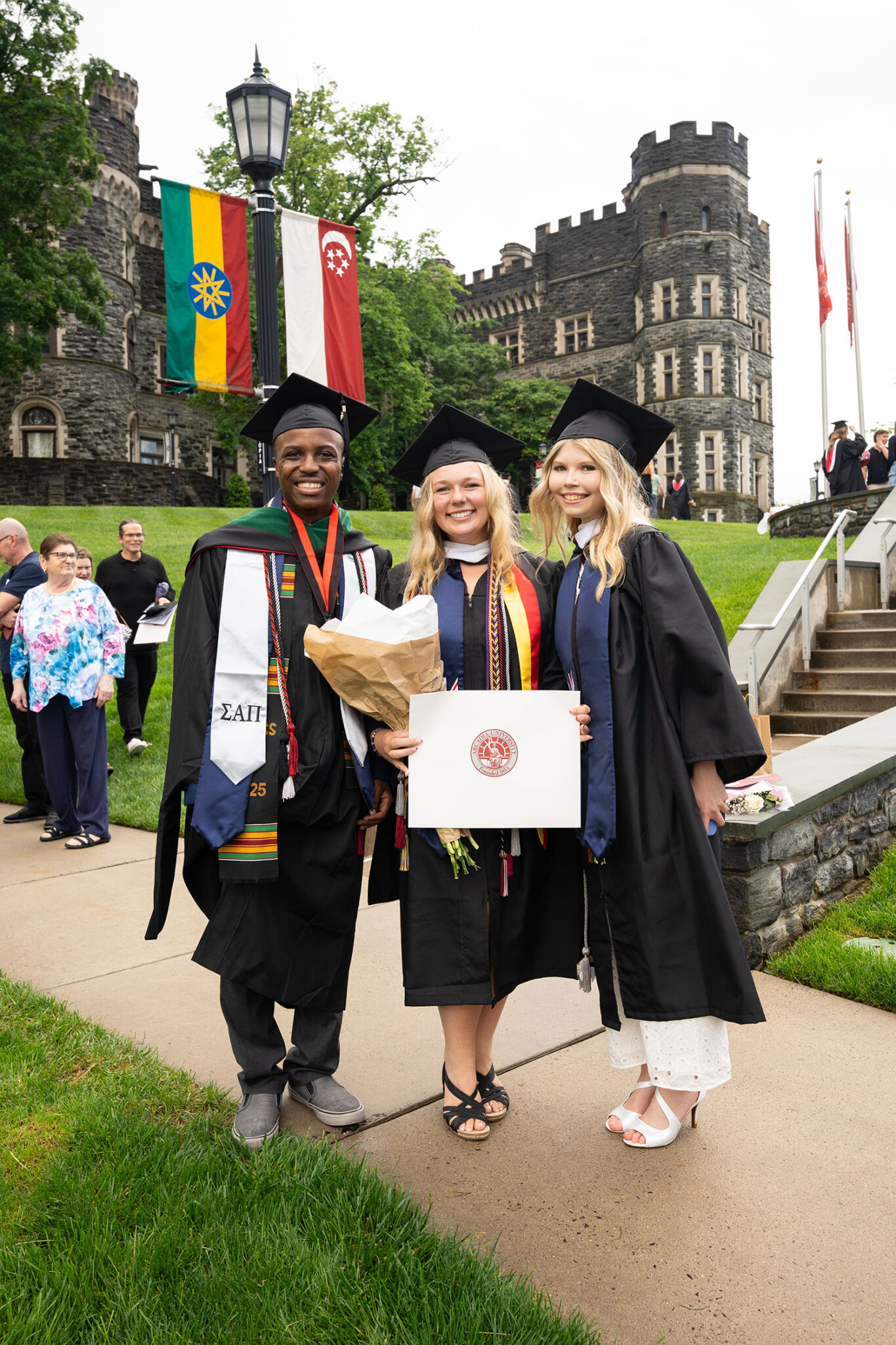 Three students standing in front of the castle.