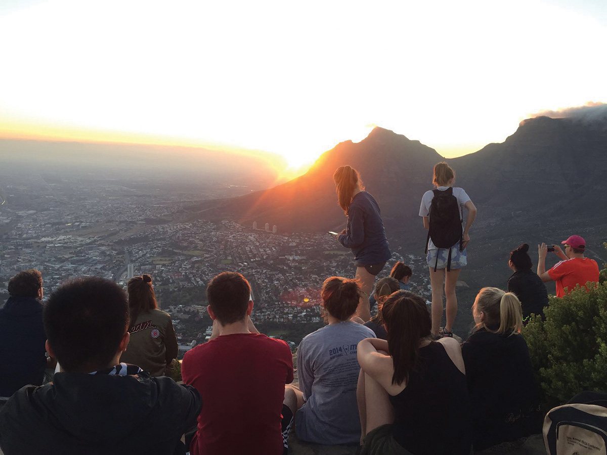 Students studying in South Africa watch the sunrise from Table Mountain in Cape Town.