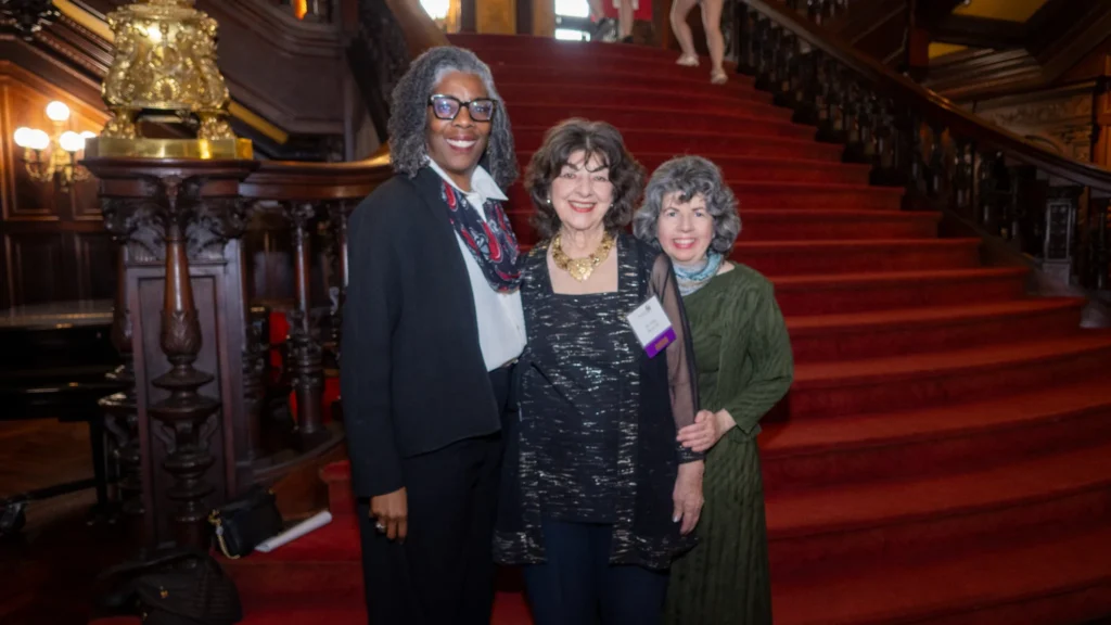 Three ladies posed in front of the Grey Towers Castle staircase.