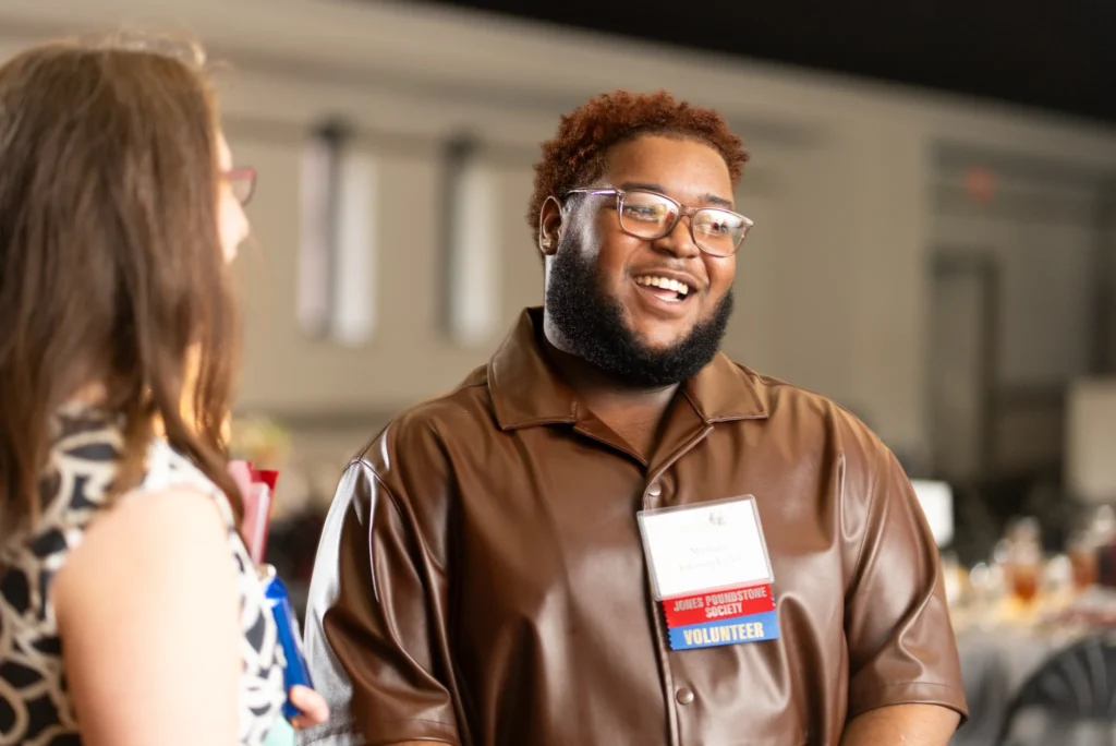 Young man smiling while in a discussion.