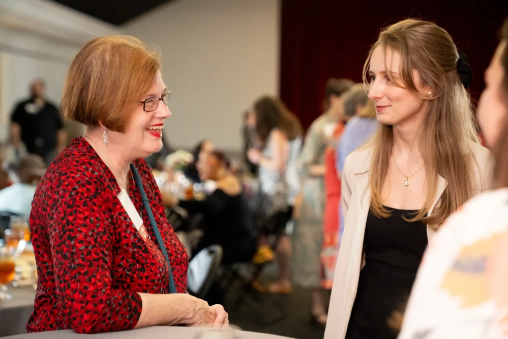 Two women in conversation and smiling.
