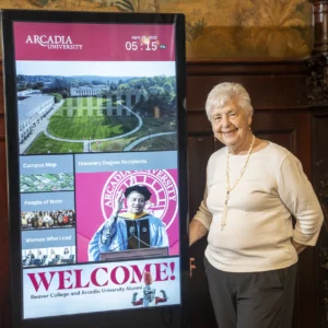 Barbara Nodine, professor emeritus and former University provost, stands by an interactive kiosk of Honorary Degree recipients.