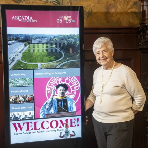 Barbara Nodine, professor emeritus and former University provost, stands by an interactive kiosk of Honorary Degree recipients.