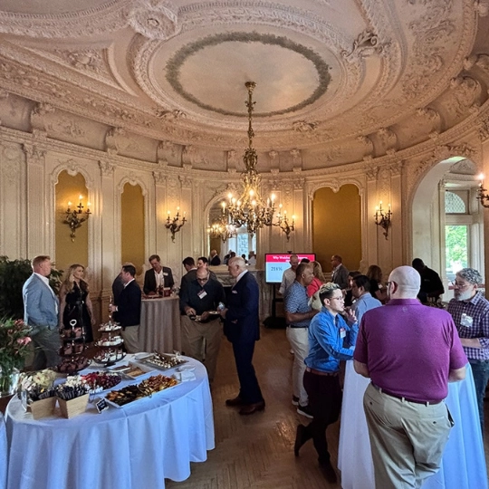 A business group meets in a historical room in Grey Castle.