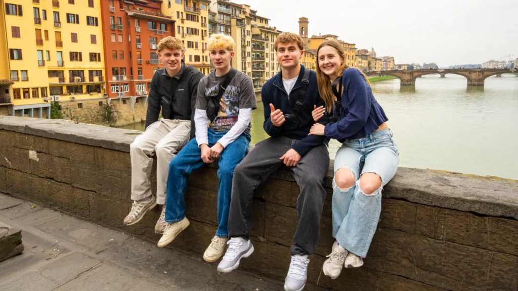Four Arcadia students sit on a wall during their time studying abroad in Florence, Italy.