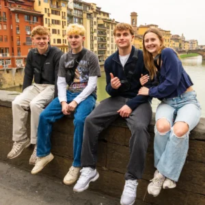 Four Arcadia students sit on a wall during their time studying abroad in Florence, Italy.