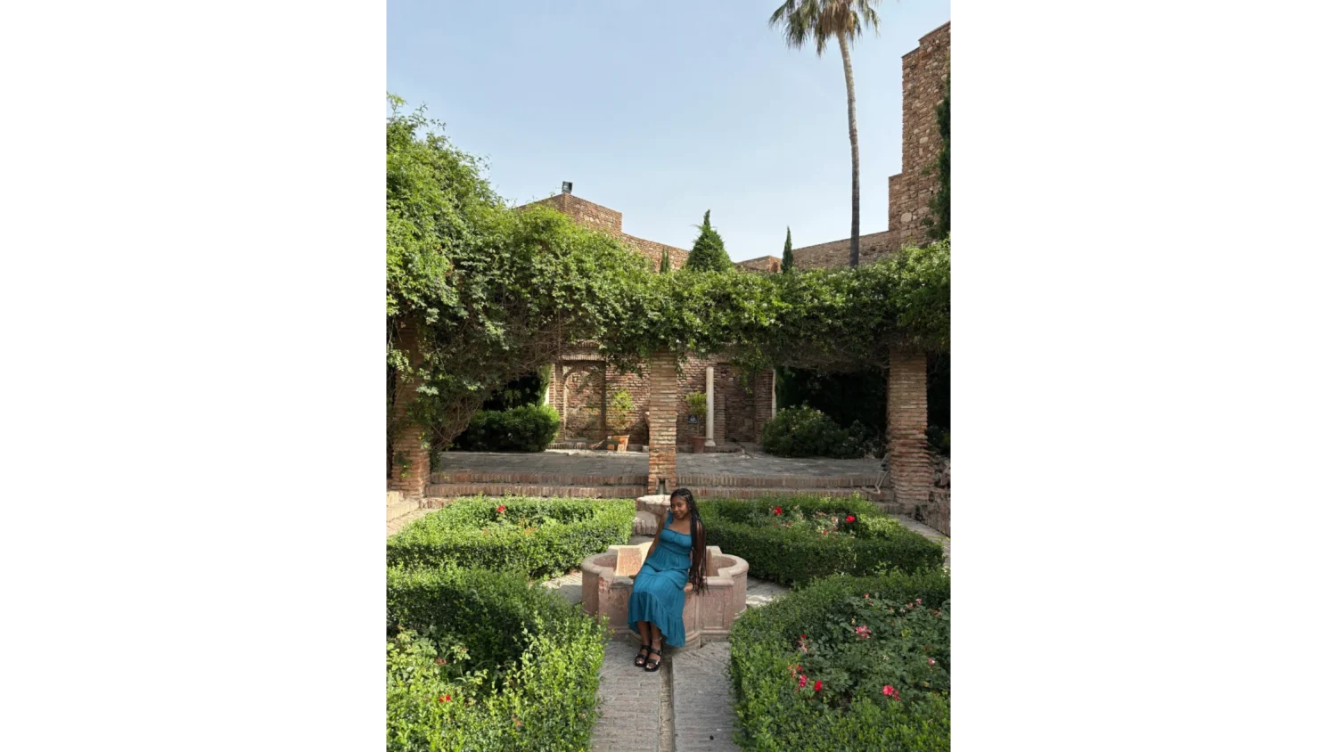 An Arcadia student sits on the edge of a stone fountain near in a garden in Granada, Spain.