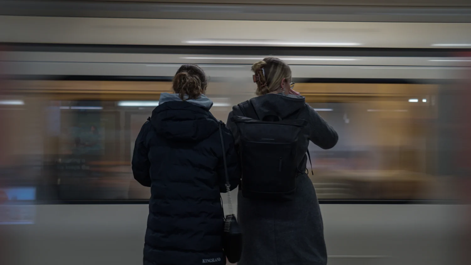 Two Arcadia students stand in front of a moving train in London, England.