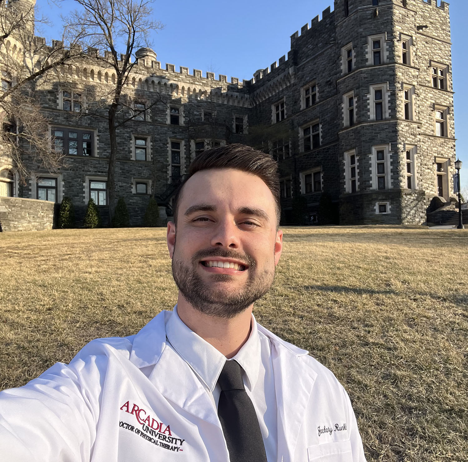 Zachary Runkle ’23, ’25DPT in front of the Castle.