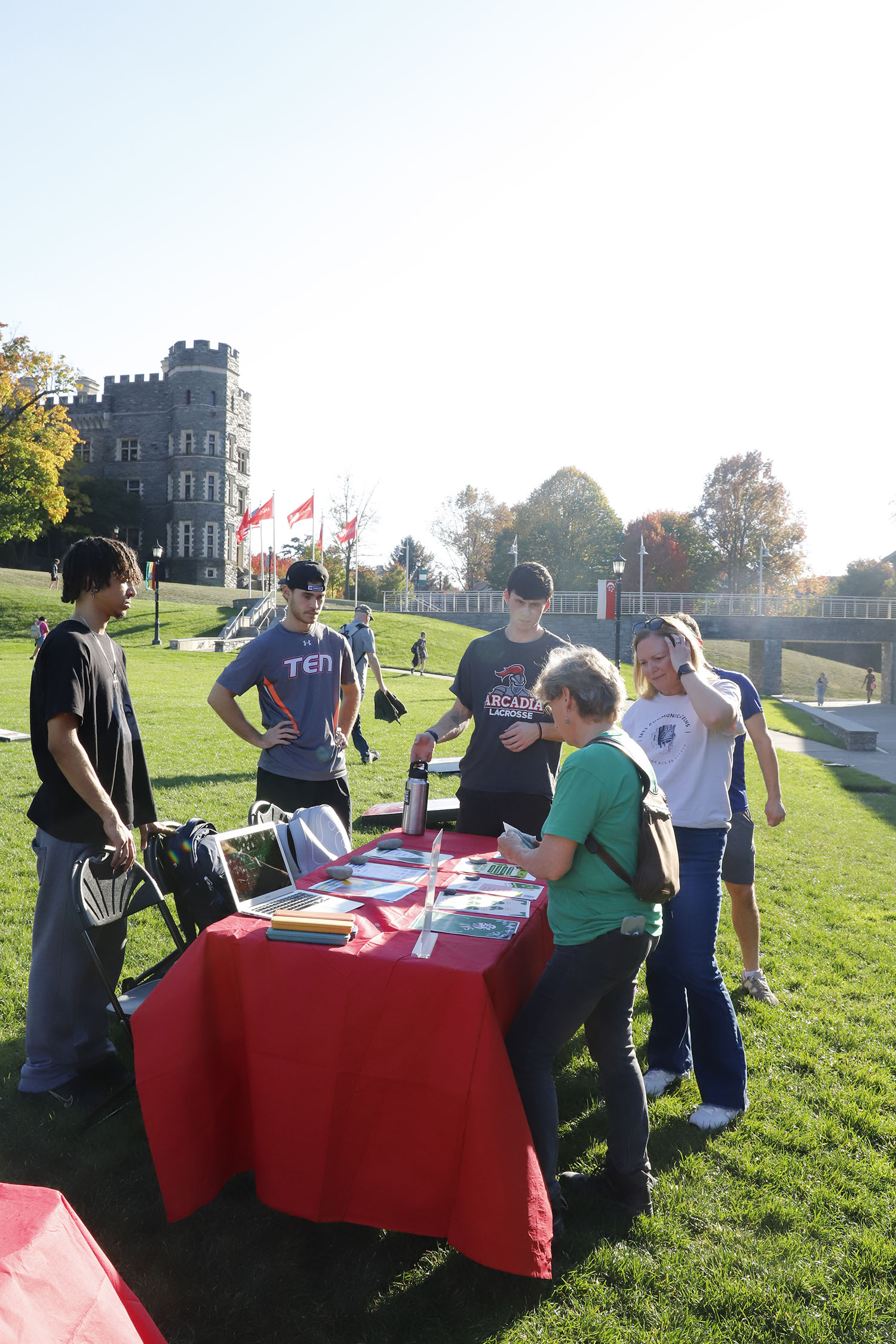 Students standing around a table with Dr. Chris Mullin and a guest on Haber Green.