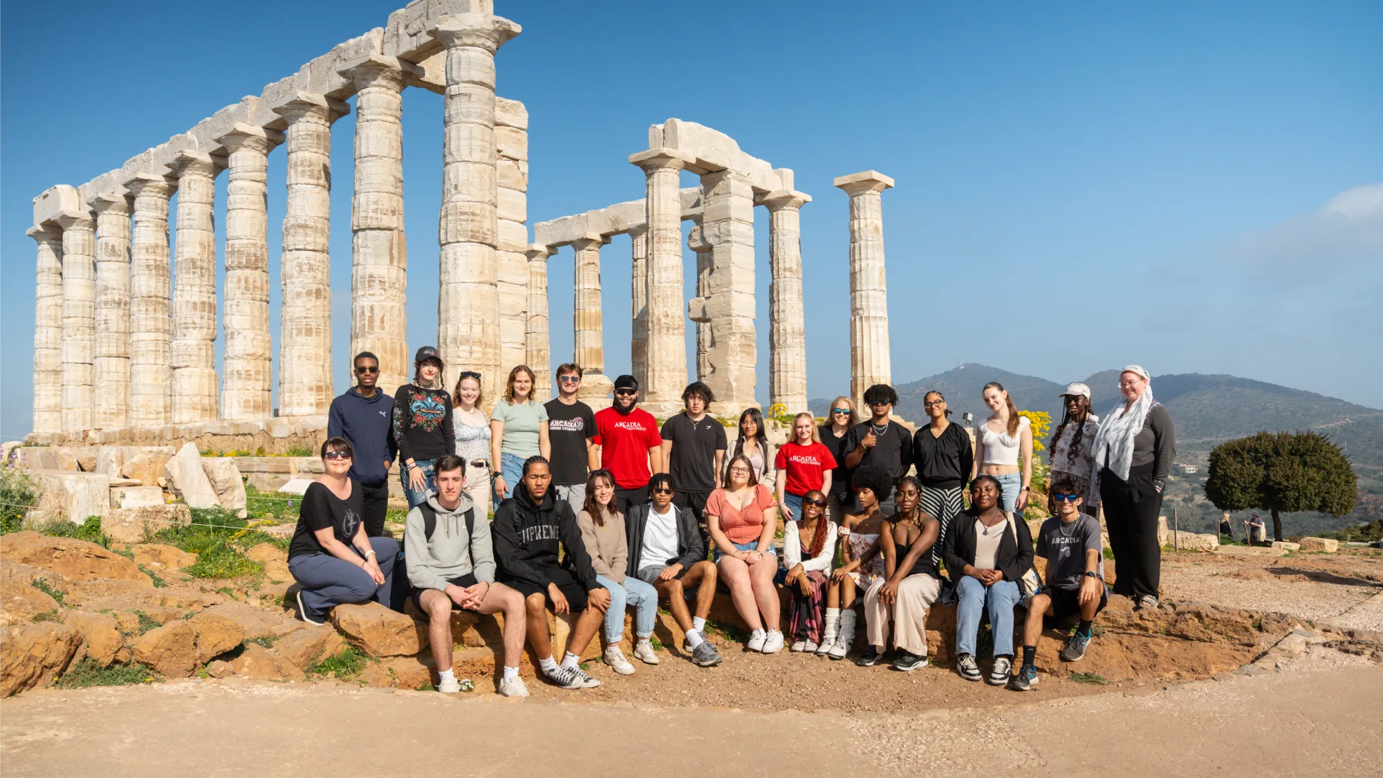 A group of Arcadia students smile in front of the Temple of Poseidon during their time studying abroad in Athens, Greece.