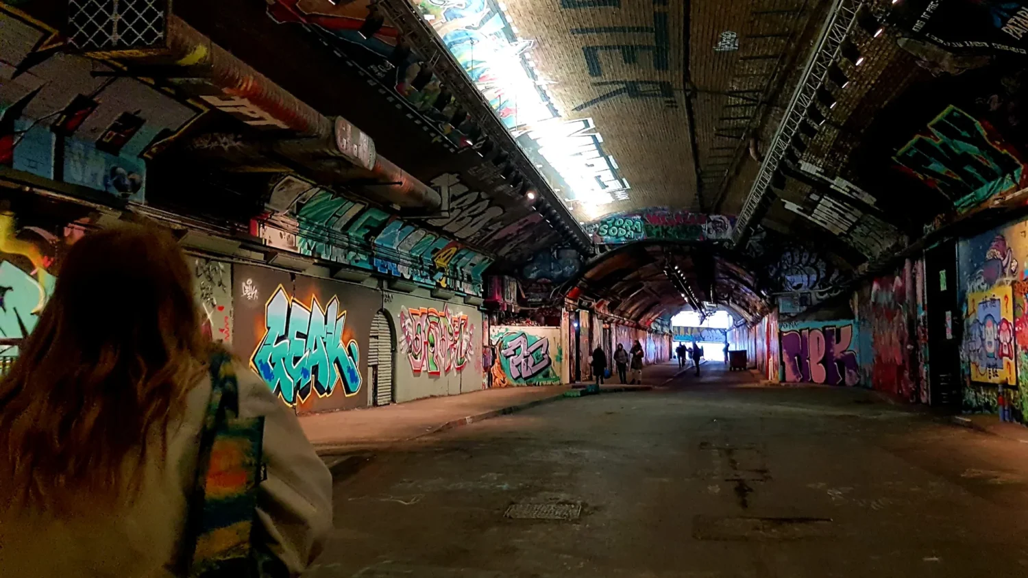 An Arcadia student walks through a tunnel tagged with graffiti in London, England.